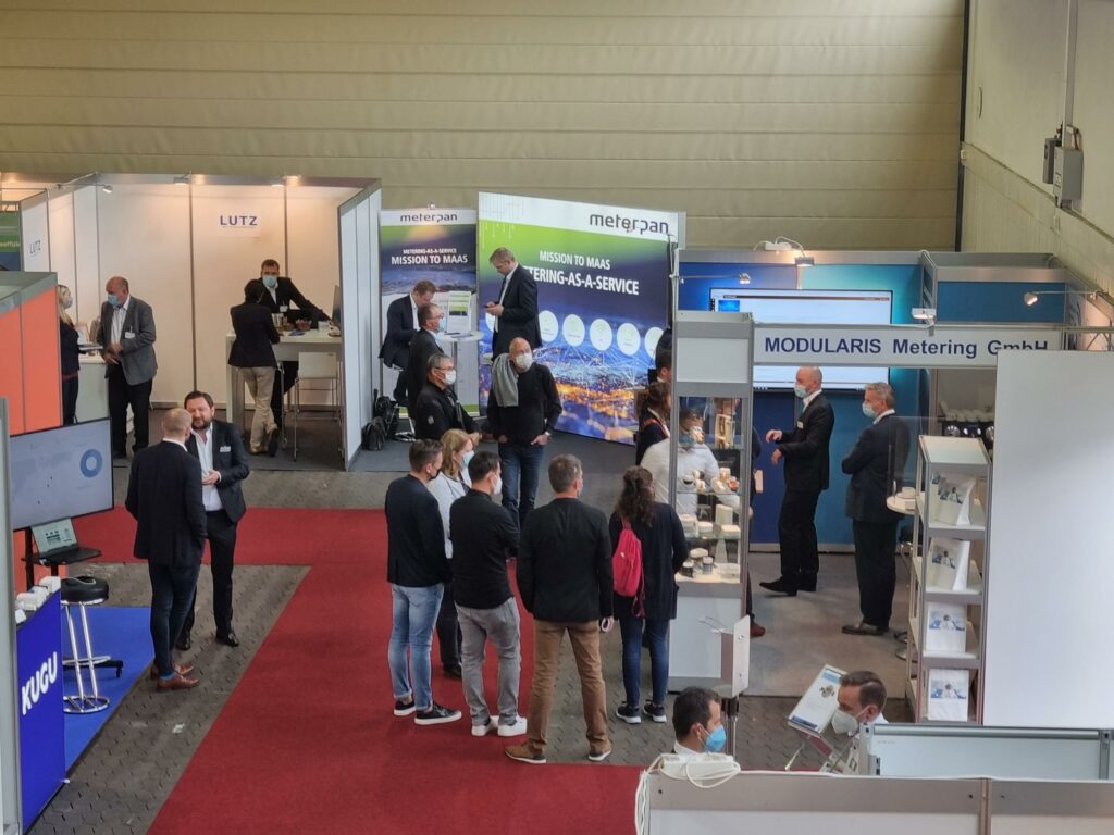 Besucher auf einer Industriemesse mit verschiedenen Ständen